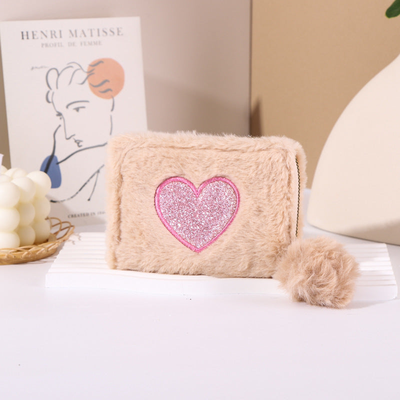 Porte-monnaie en peluche avec fermeture éclair brodée de cœur.