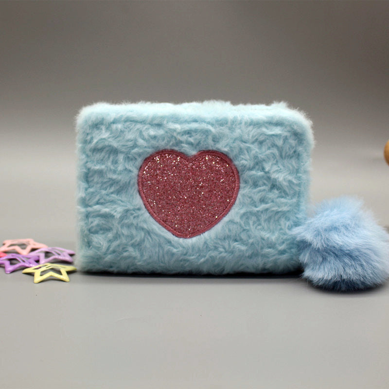 Porte-monnaie en peluche avec fermeture éclair brodée de cœur.