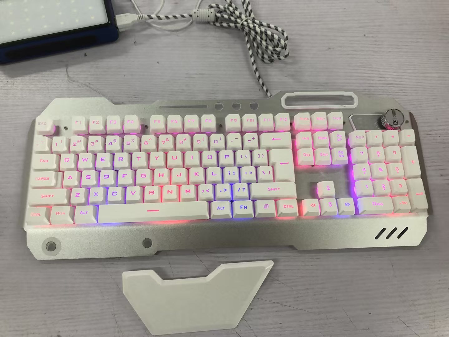 Clavier de jeu filaire ergonomique avec rétroéclairage RGB et support pour téléphone.