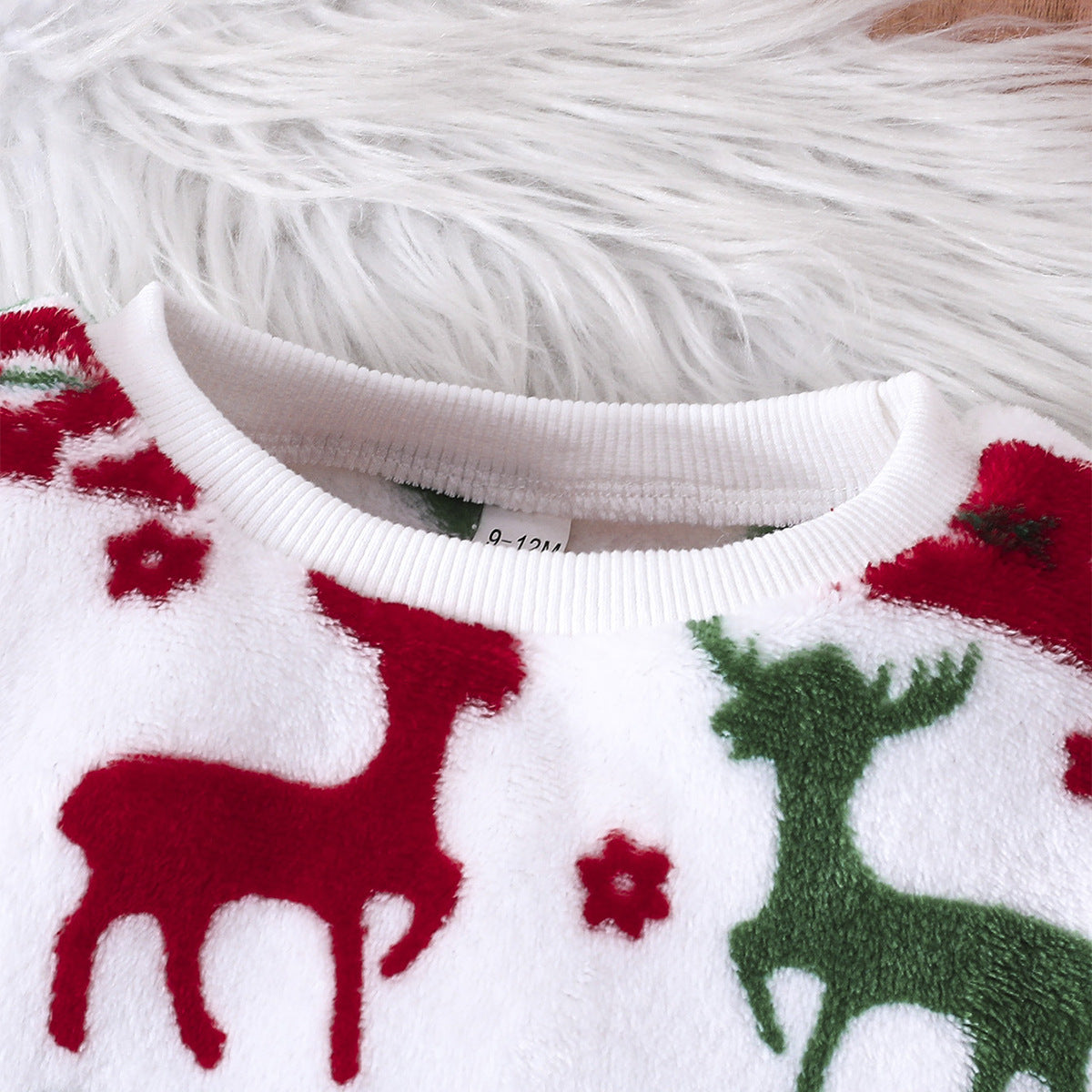 Ensemble de deux pièces comprenant un pull à col rond à manches longues avec motif de Noël et un pantalon.