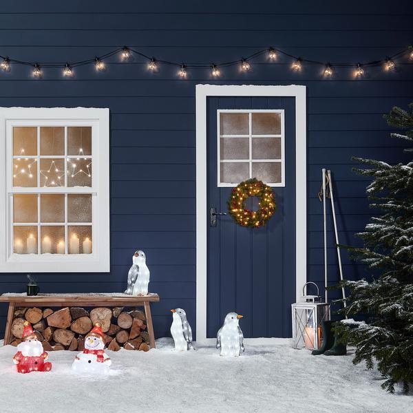Décoration de Noël en acrylique en forme de pingouin avec lumières et ornements.